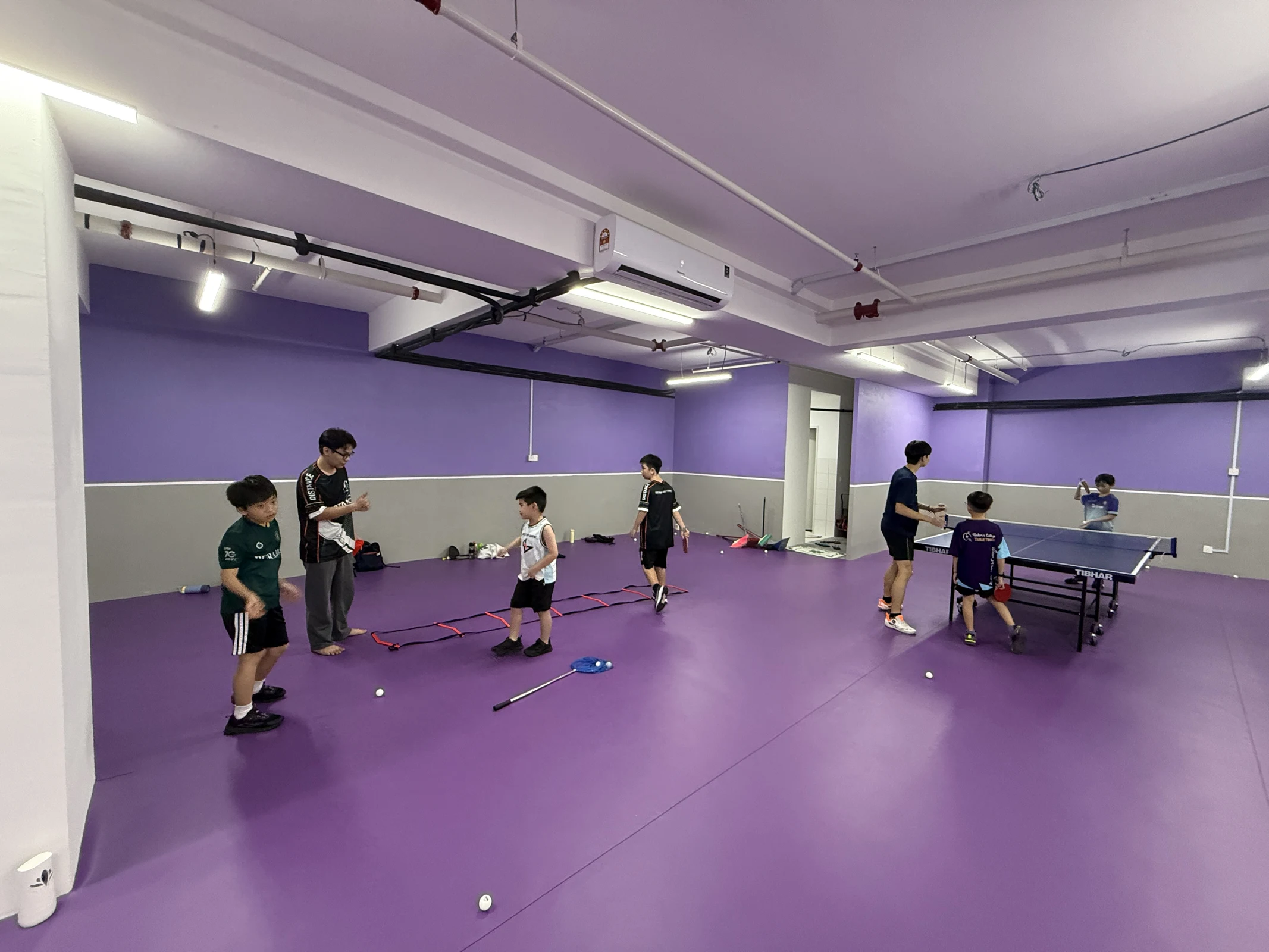 Children learning coordination and table tennis with coaches